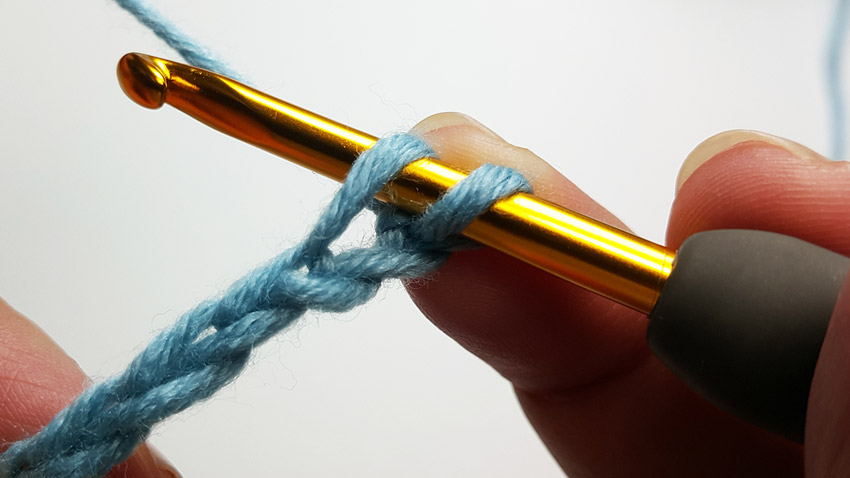 an image showing the crochet hook inserted into the top loop of the chain